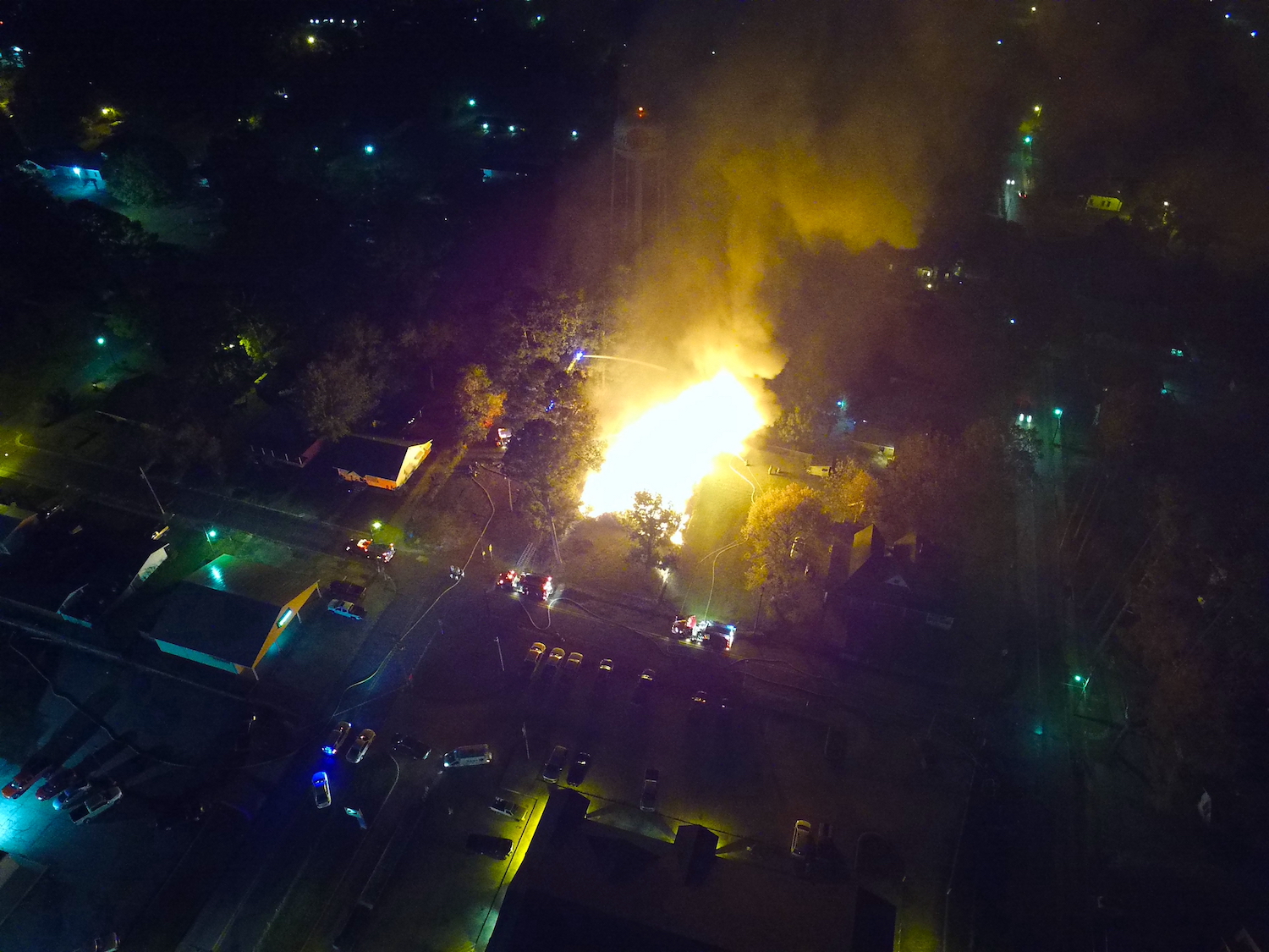 A fire is burning in the middle of a city.
