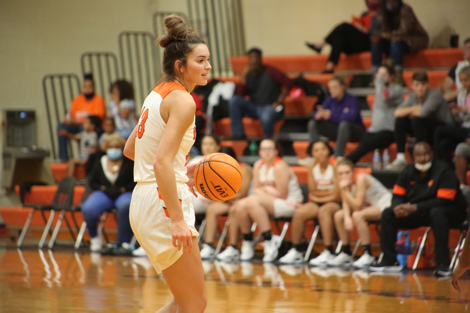 A girl in white shorts holding a basketball.