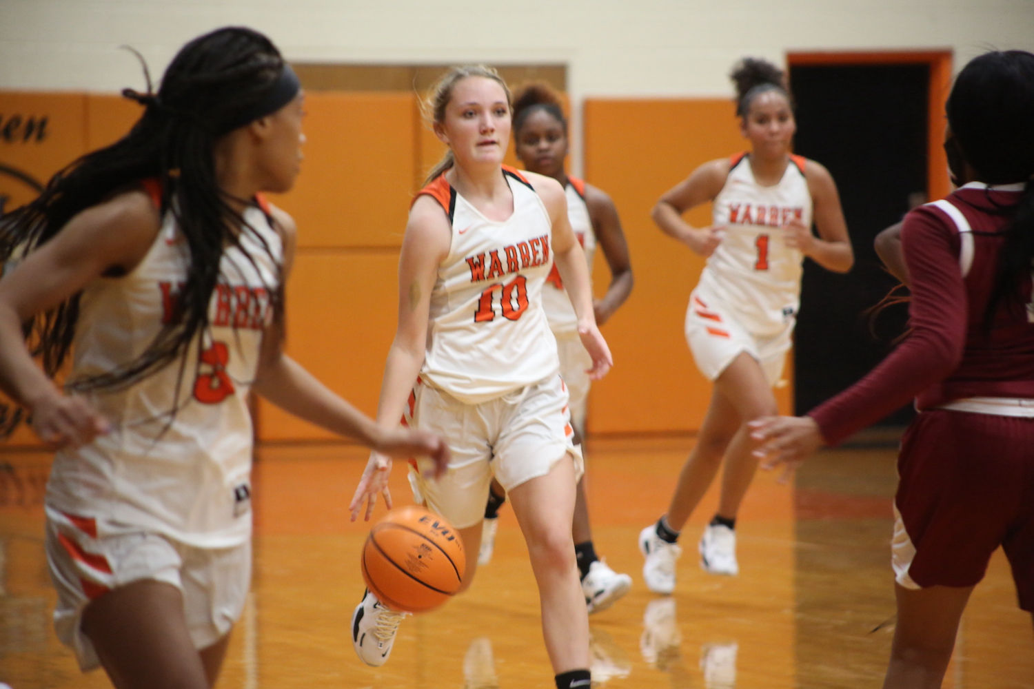 A group of girls playing basketball on the court.