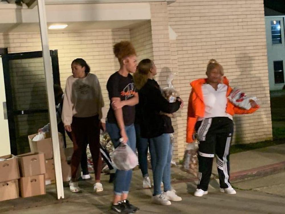 A group of people standing around in front of some buildings.