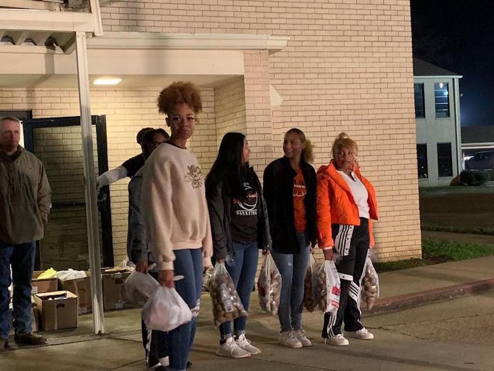 A group of people standing on the sidewalk.