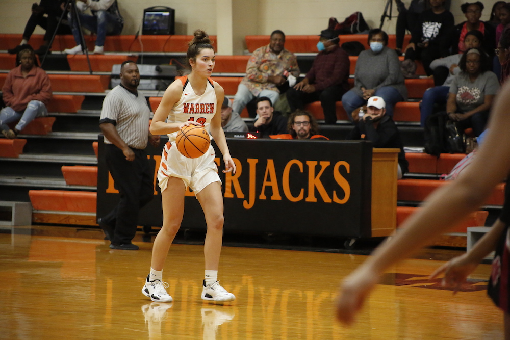 A girl is holding a basketball in her hand.