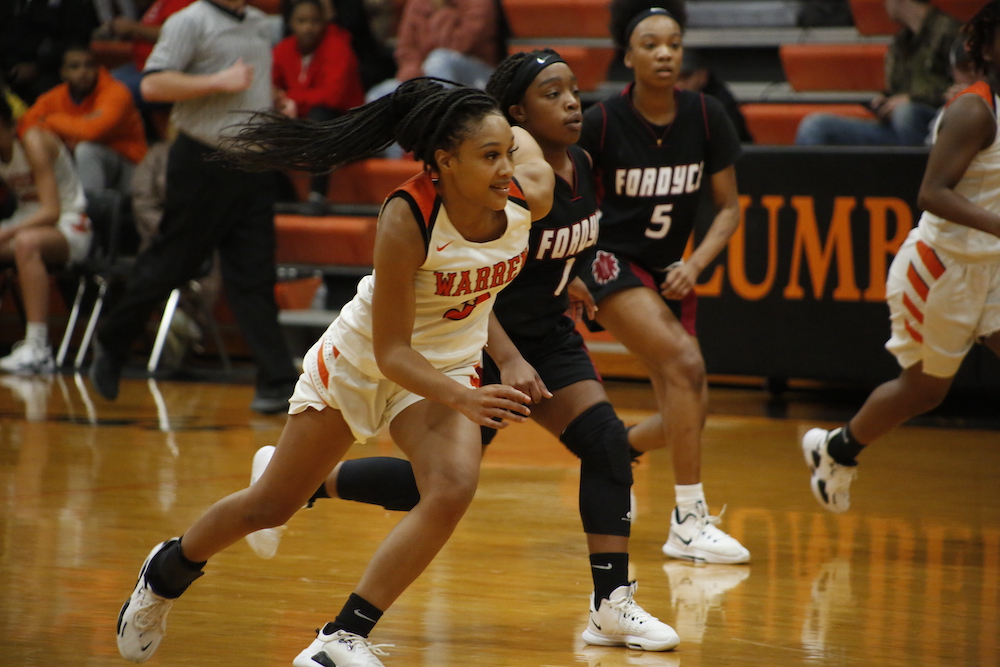 A group of girls playing basketball on the court.