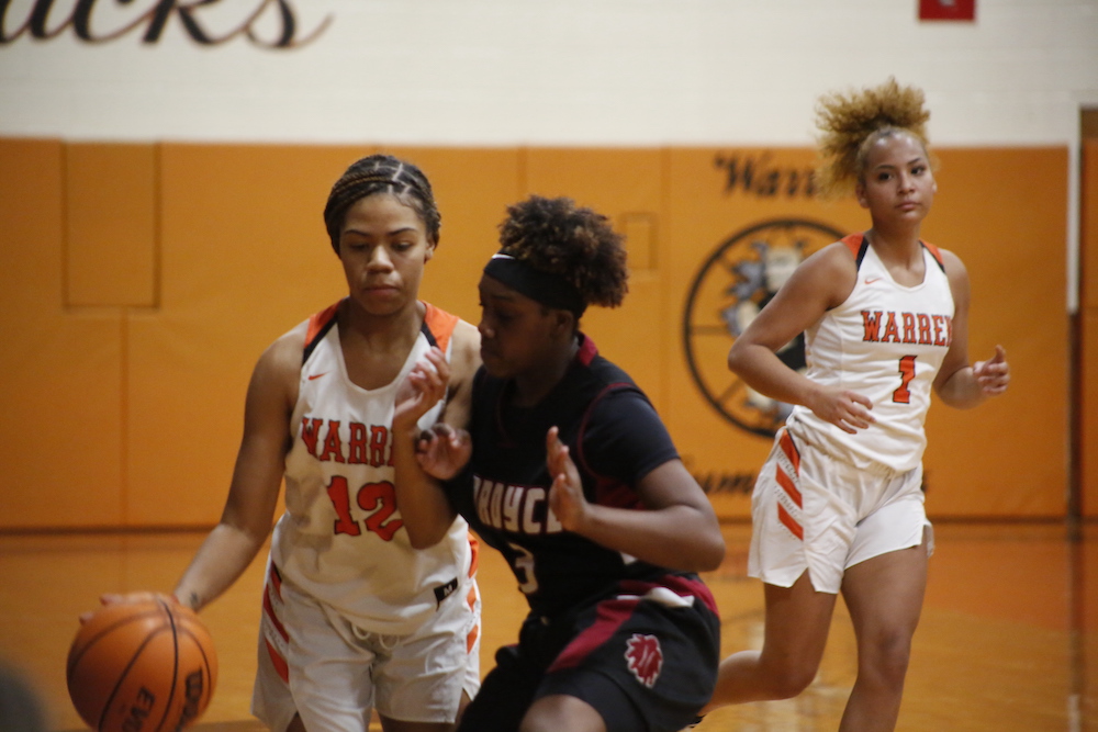 A group of women playing basketball on an indoor court.