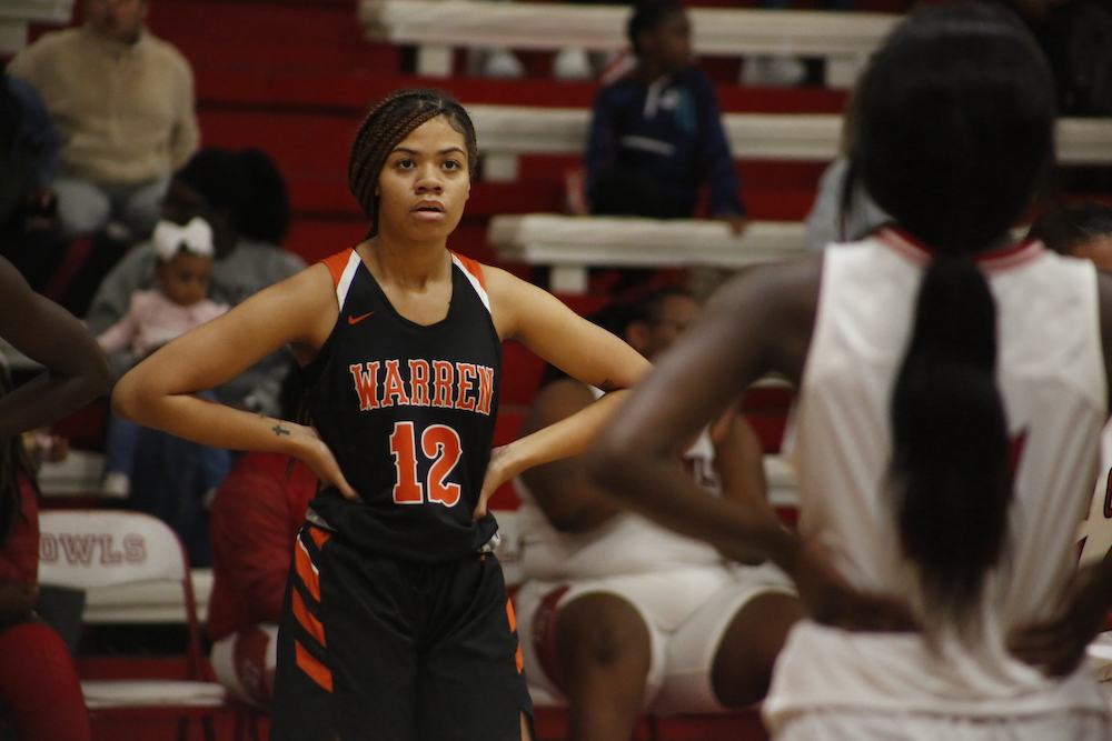 A girl in black and orange basketball uniform.