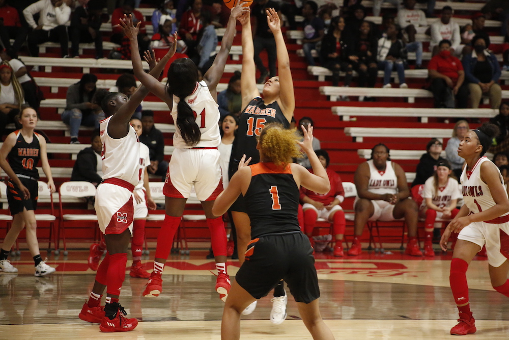 A group of people playing basketball on a court.