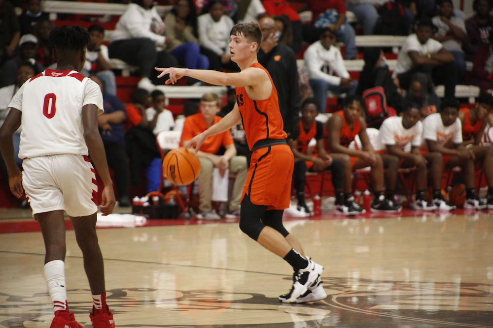 A basketball player in an orange and black uniform.