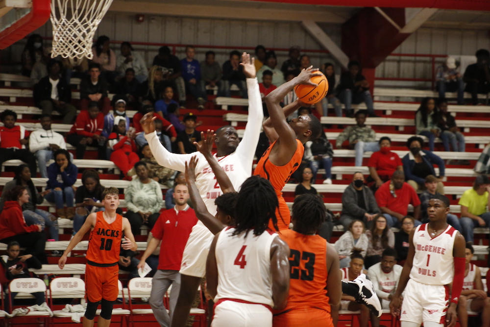 A group of people playing basketball in front of an audience.