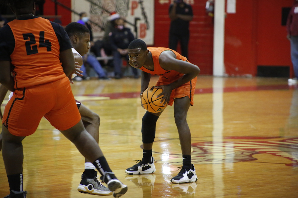 A basketball player is holding the ball while playing on the court.
