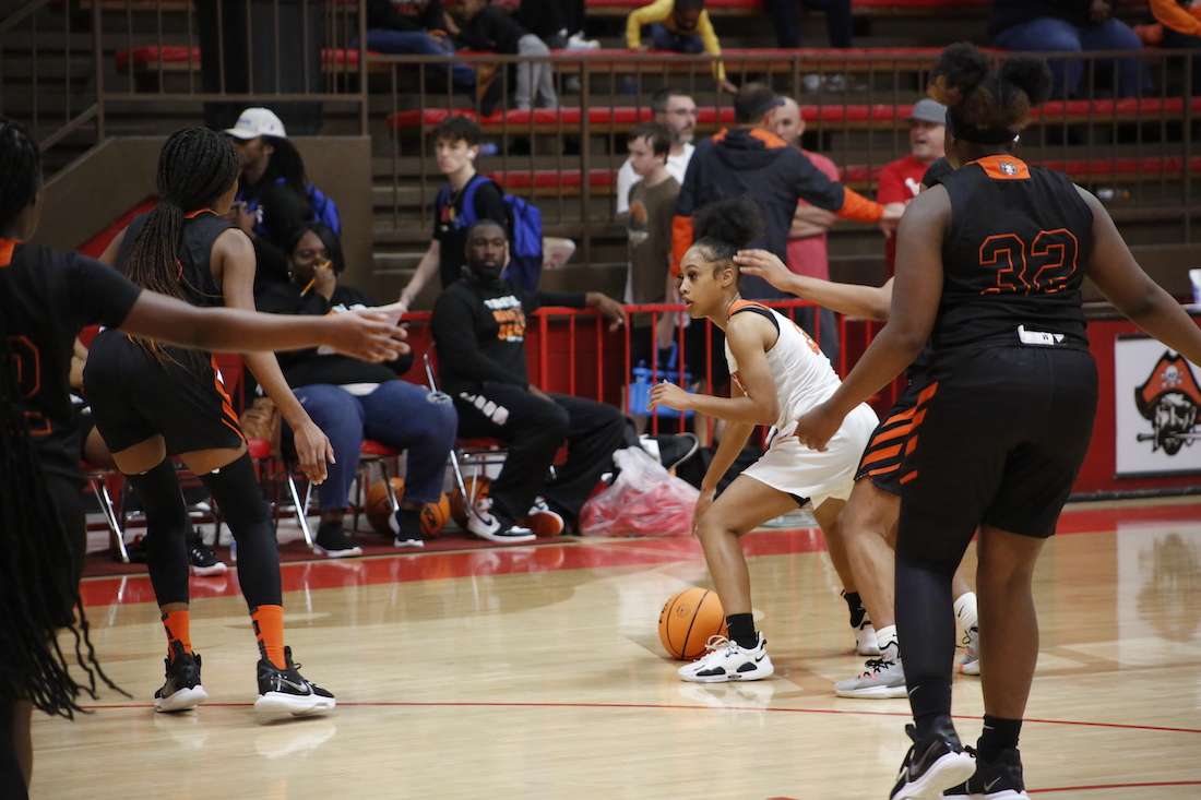 A group of people playing basketball on a court.