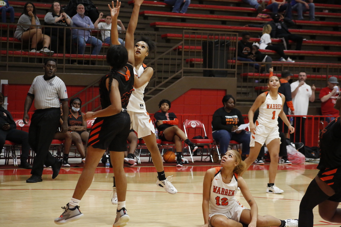 A group of girls playing basketball on the court.