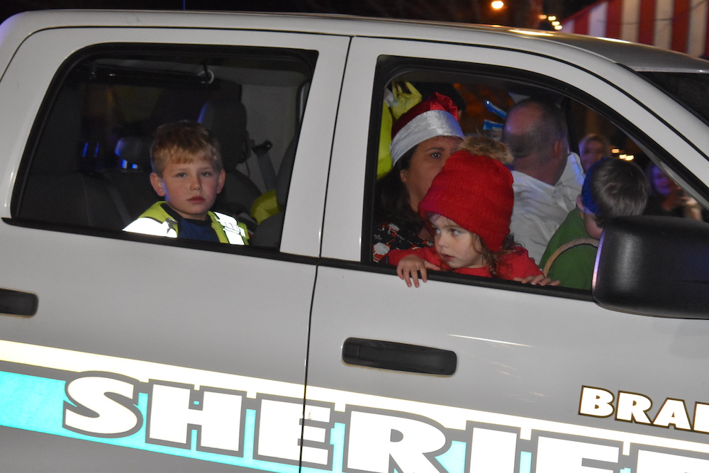 A group of people in the back of a police car.