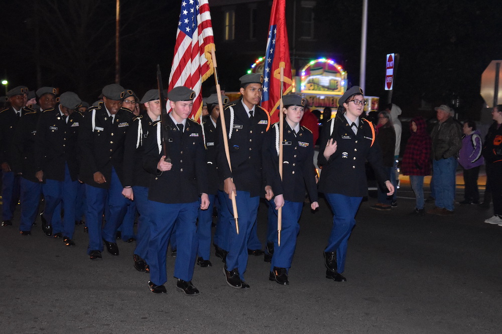 A group of men in uniform marching down the street.