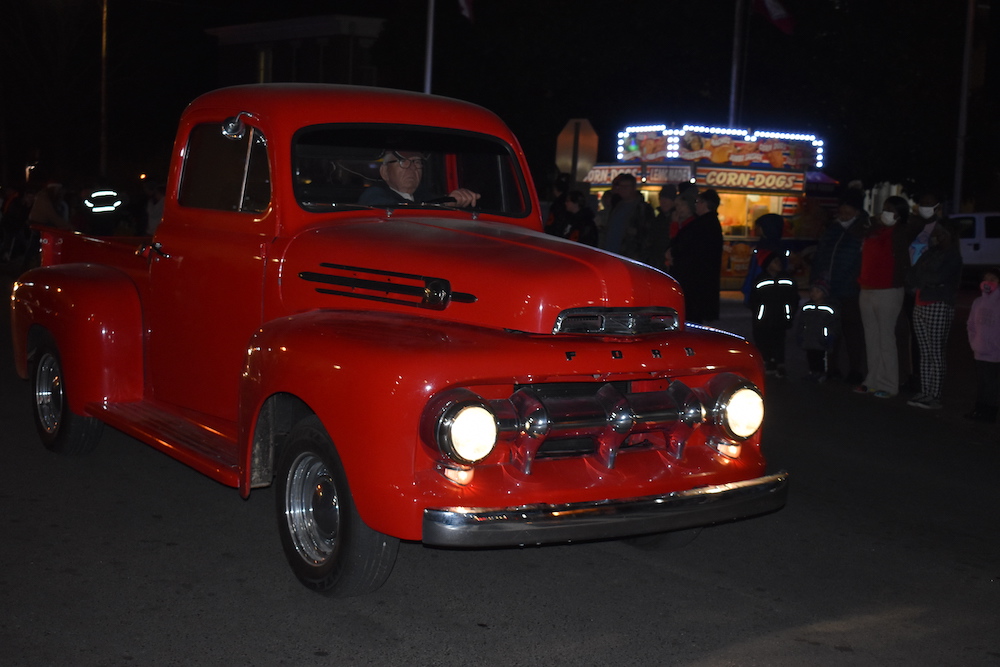 A red truck is driving down the street.