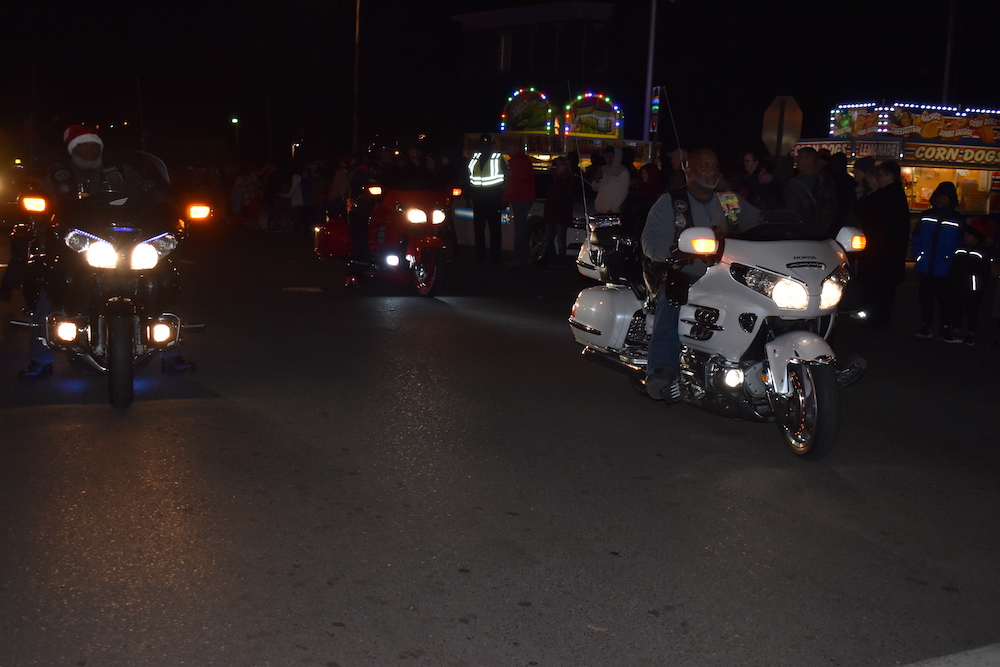 A group of people on motorcycles driving down the street.