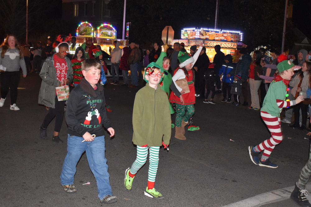 A group of people in costumes walking down the street.