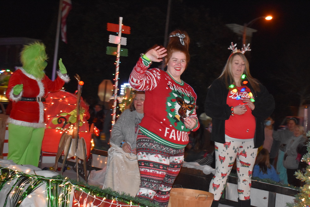 A woman in red and white sweater holding up her hand.