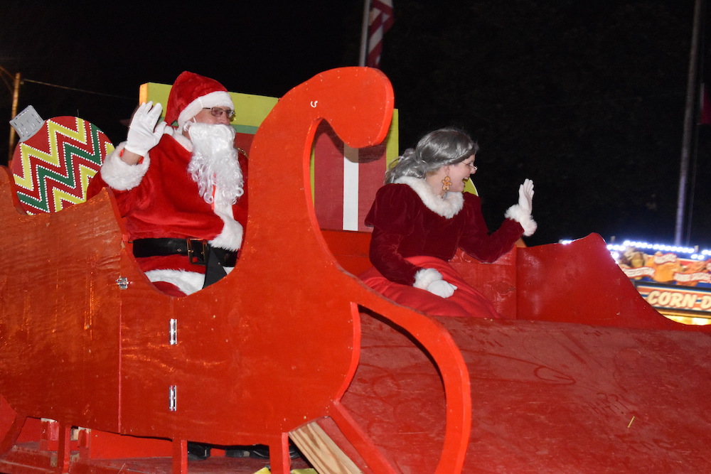 A man and woman sitting on top of a red sleigh.