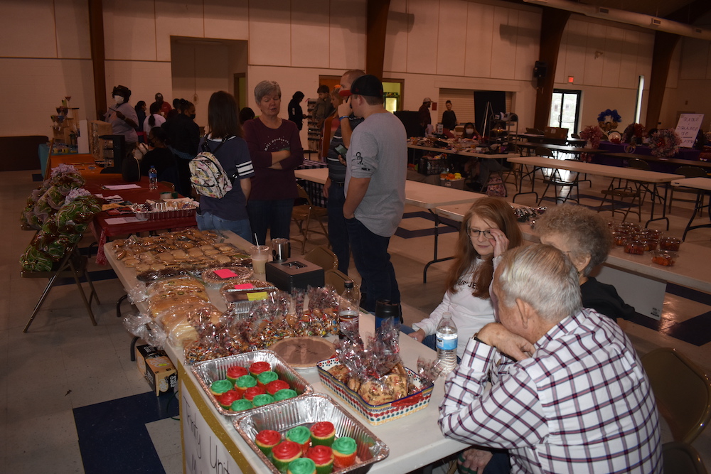 A group of people sitting around tables with food.