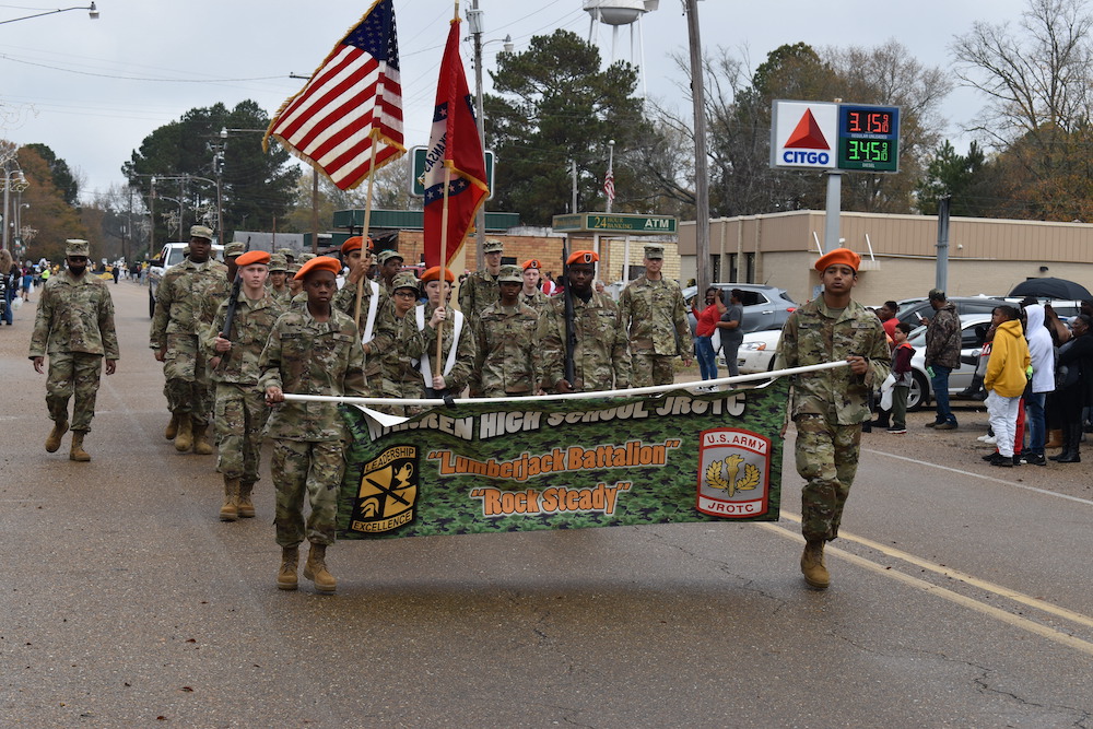 A group of people in military uniforms marching down the street.