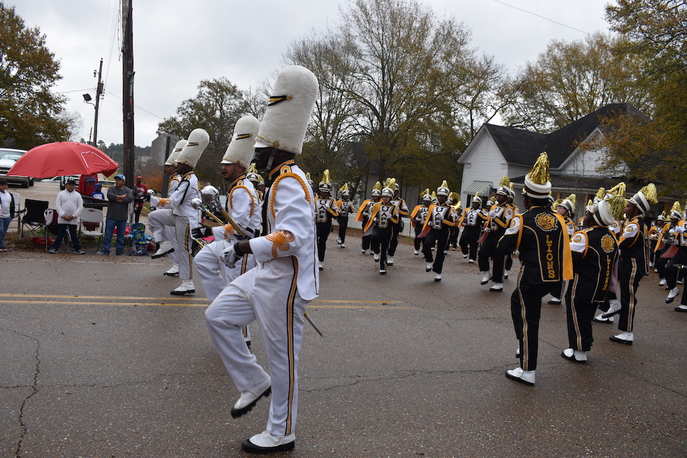 A group of people in uniforms marching down the street.