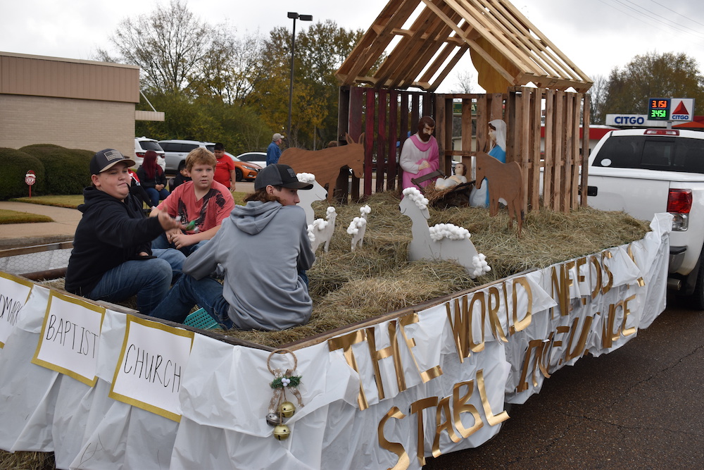 A parade float with people sitting on it.