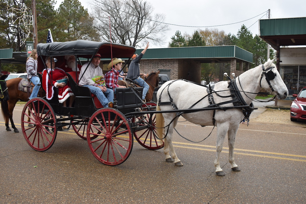 A horse drawn carriage with people in it.