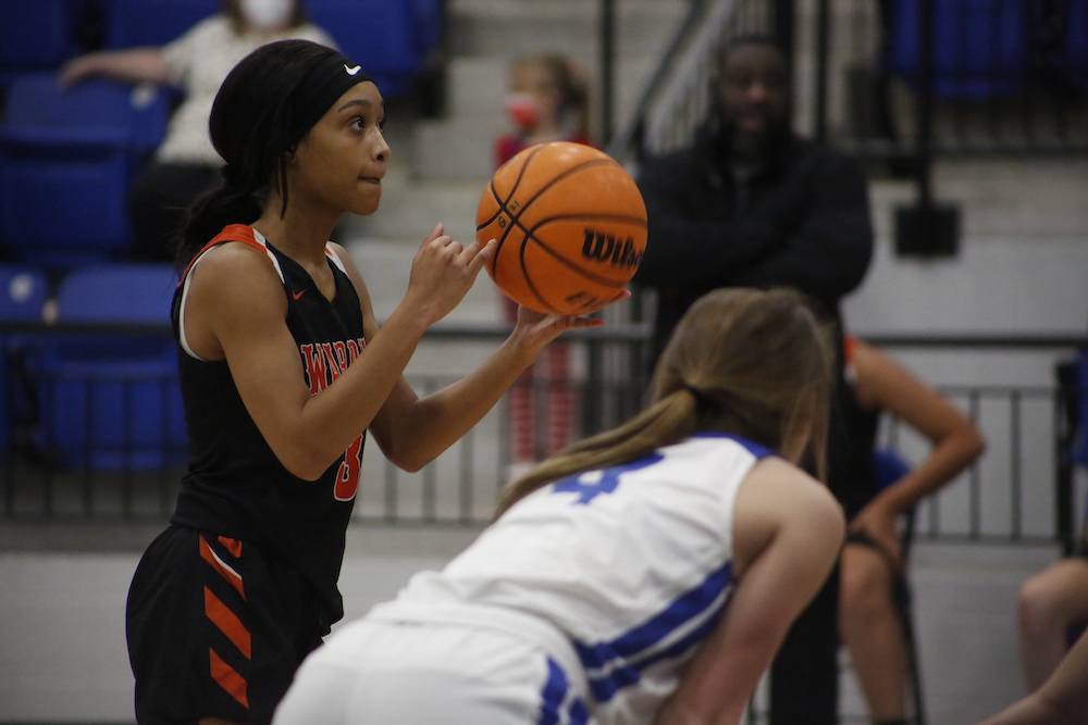 A dog in its cage with his tongue hanging out.
