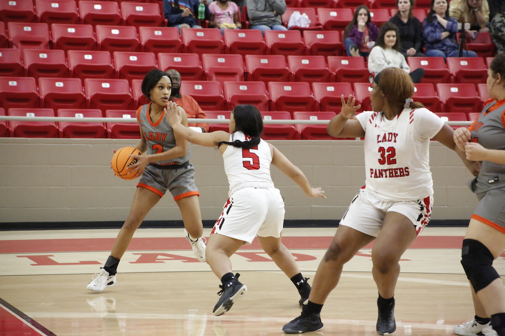 A group of women playing basketball on a court.