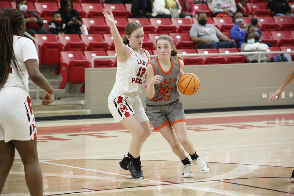 Two girls playing basketball on a court