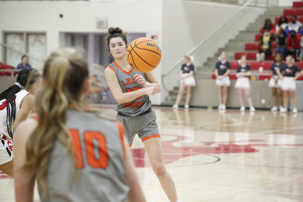 A girl is playing basketball on the court