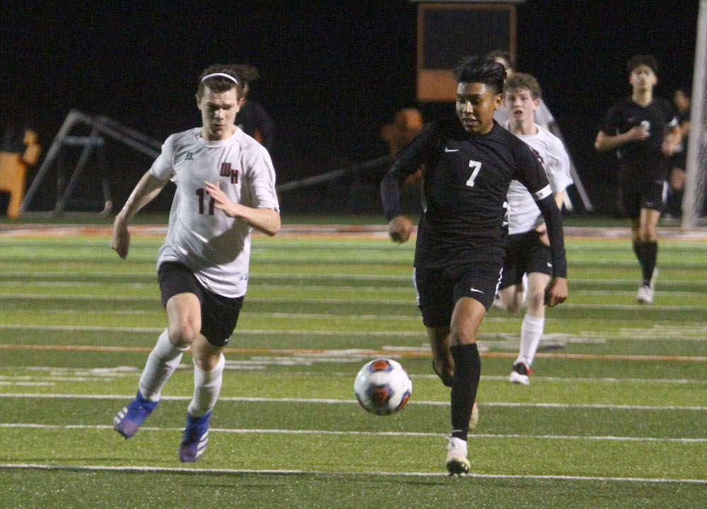 A group of young men playing soccer on a field.