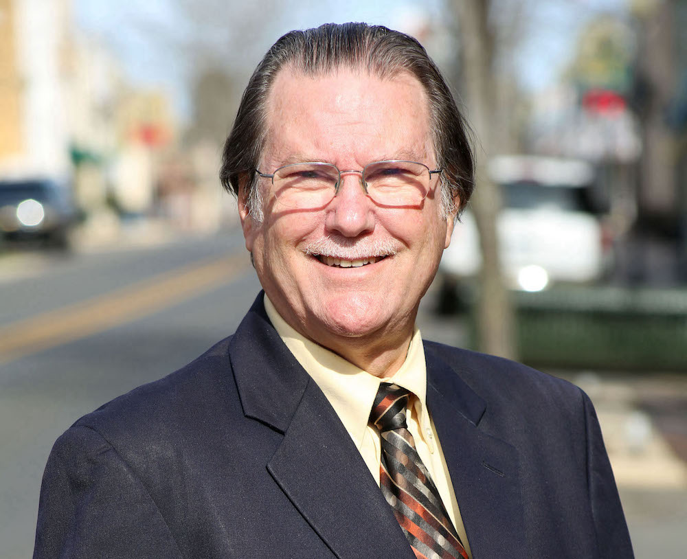 A man in a suit and tie standing on the side of a road.
