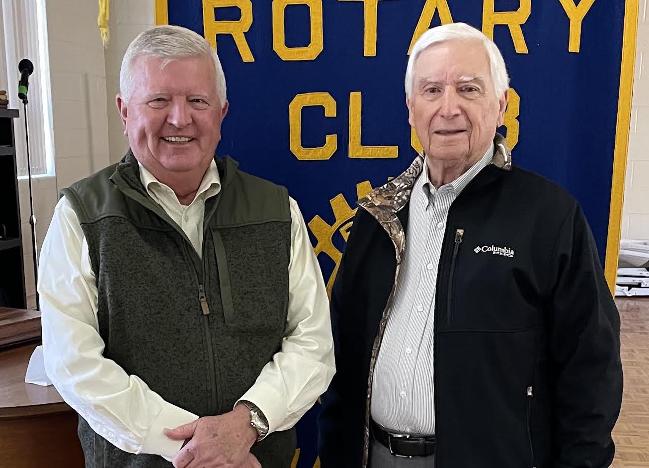 Two men standing next to each other in front of a banner.