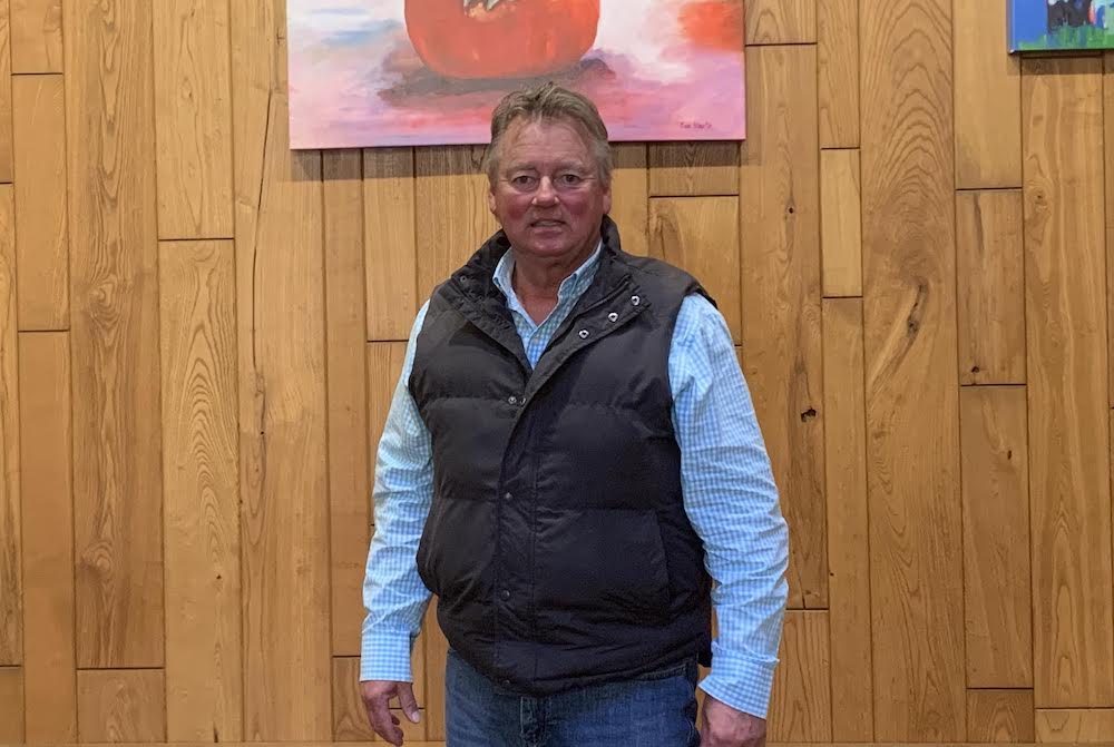 A man standing in front of a painting.