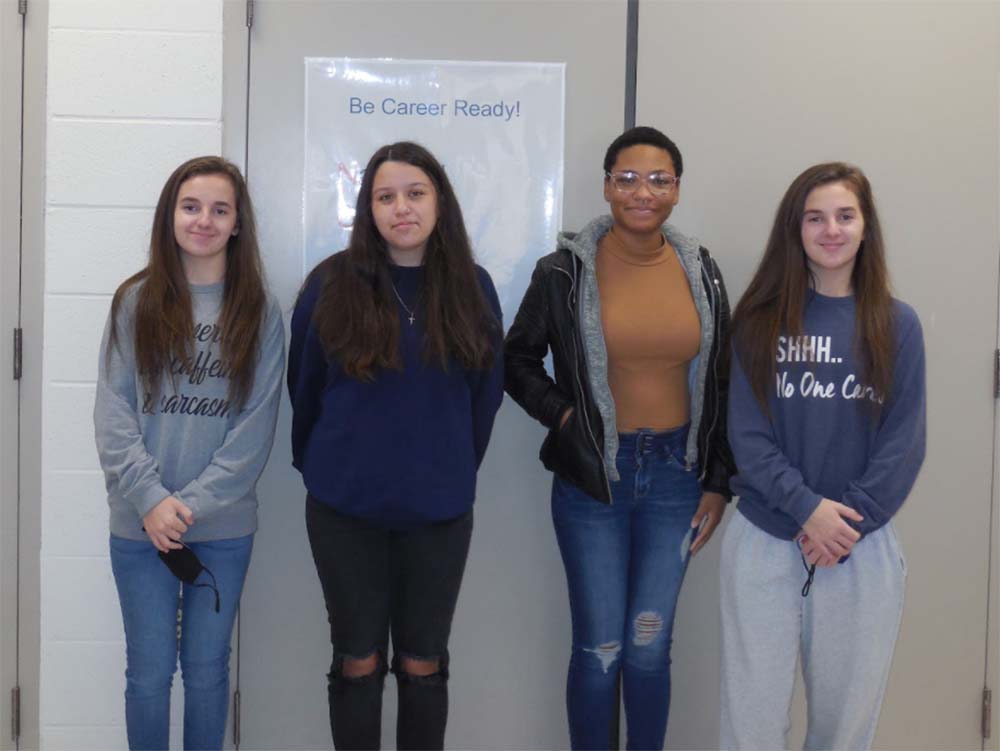 Four girls standing in front of a whiteboard.