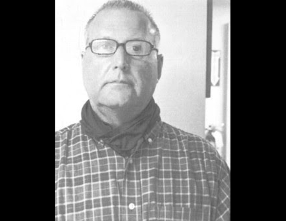 A man with glasses and a plaid shirt.