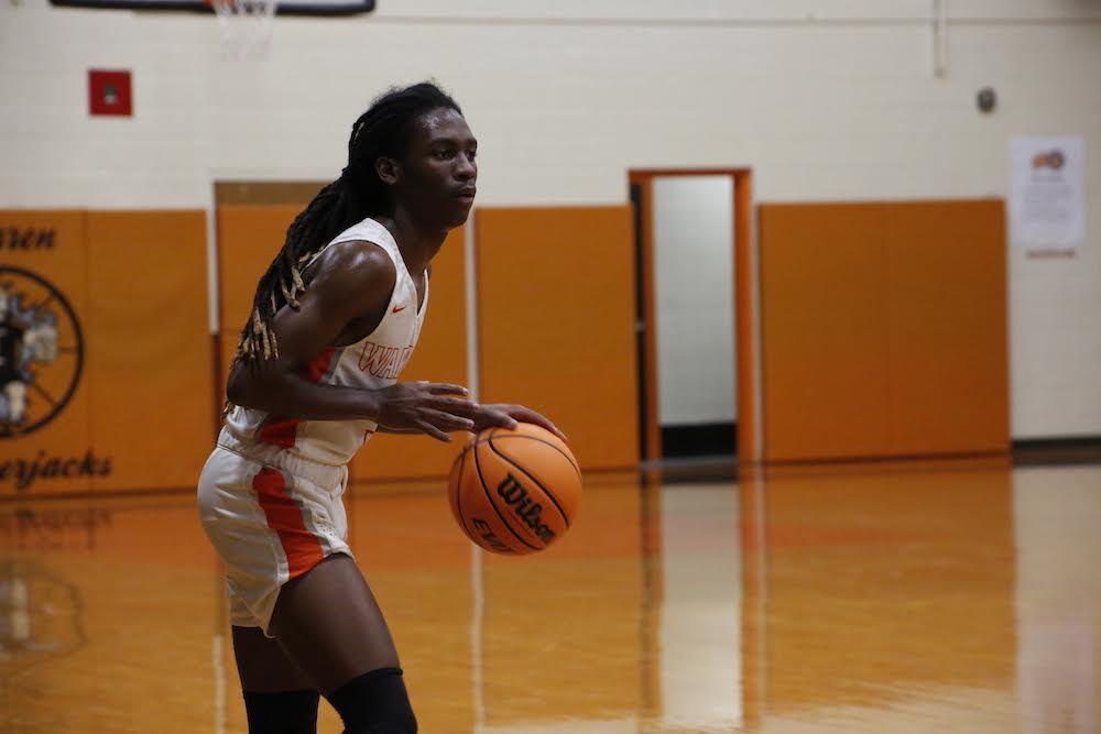 A woman holding onto a basketball on the court