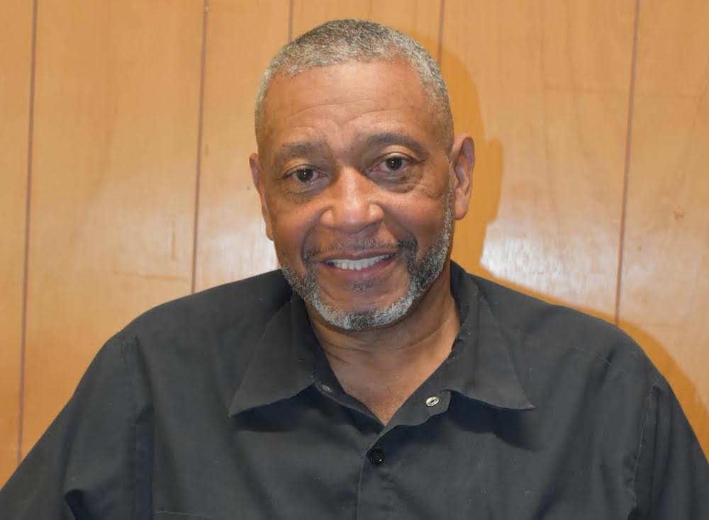 A man with gray hair and wearing a black shirt.