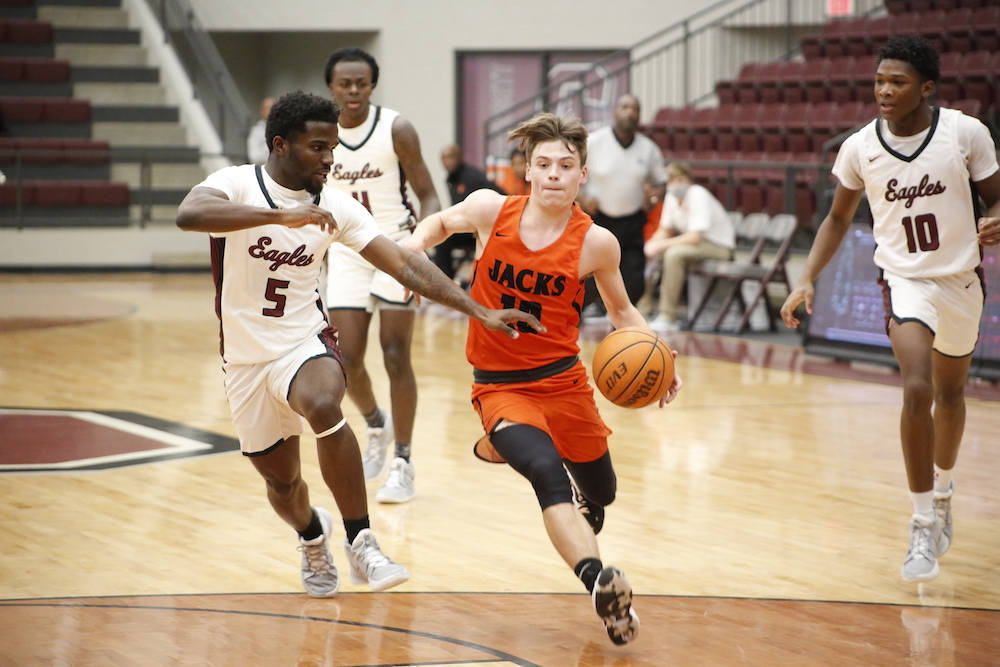 A group of young men playing basketball on a court.