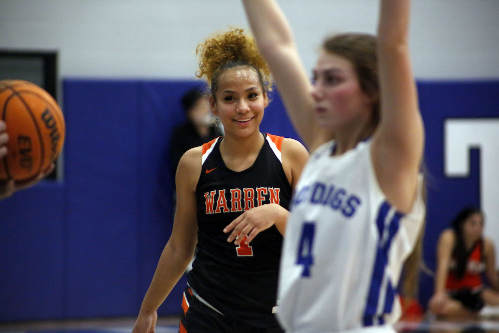 Two girls playing basketball on a court