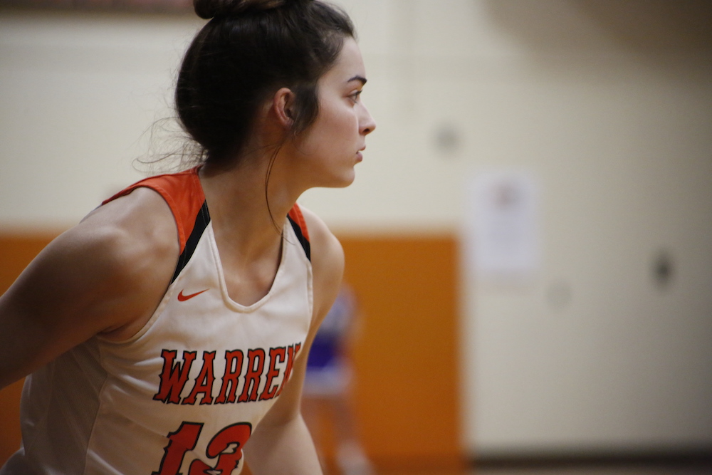 A girl in orange and white basketball uniform.