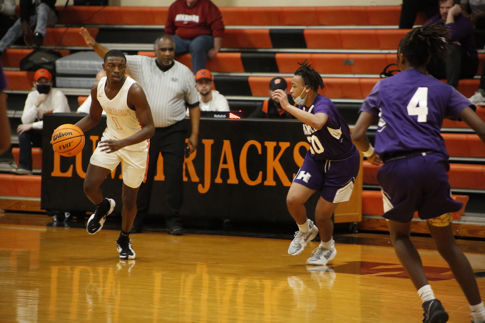 A group of people playing basketball on an indoor court.