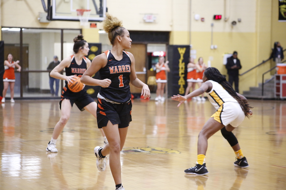 A group of girls playing basketball on the court.