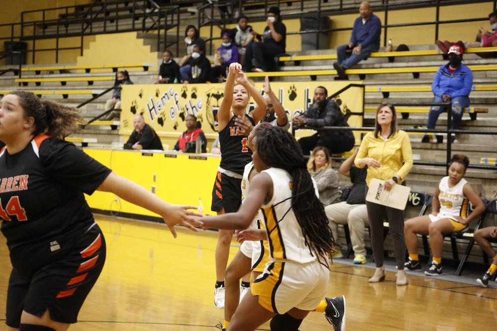 A group of people playing basketball on a court.