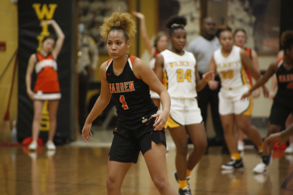 A group of girls are playing basketball on the court.