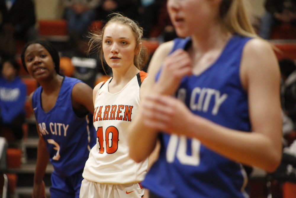 A group of girls in basketball uniforms on the court.