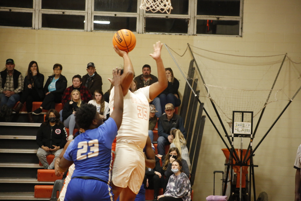 A basketball player is going up for the ball.