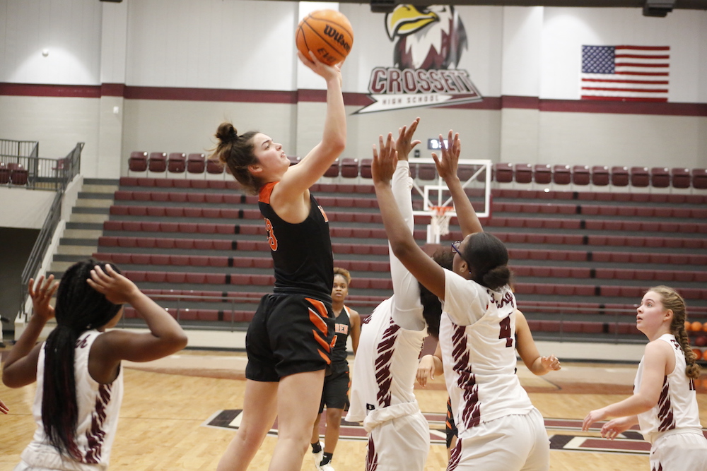 A group of women playing basketball on a court.