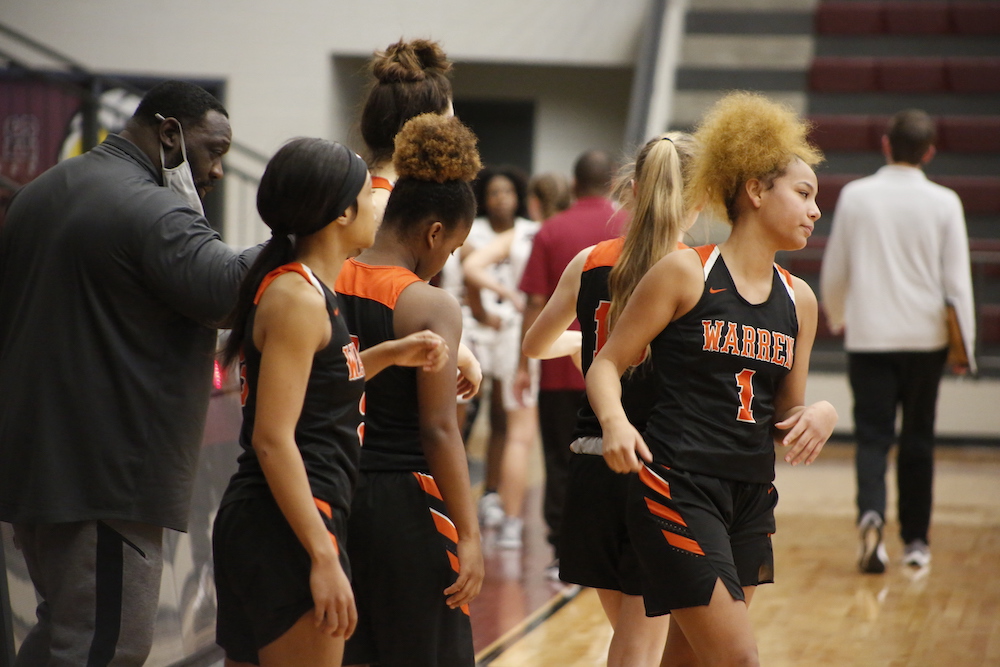 A group of women standing on top of a basketball court.